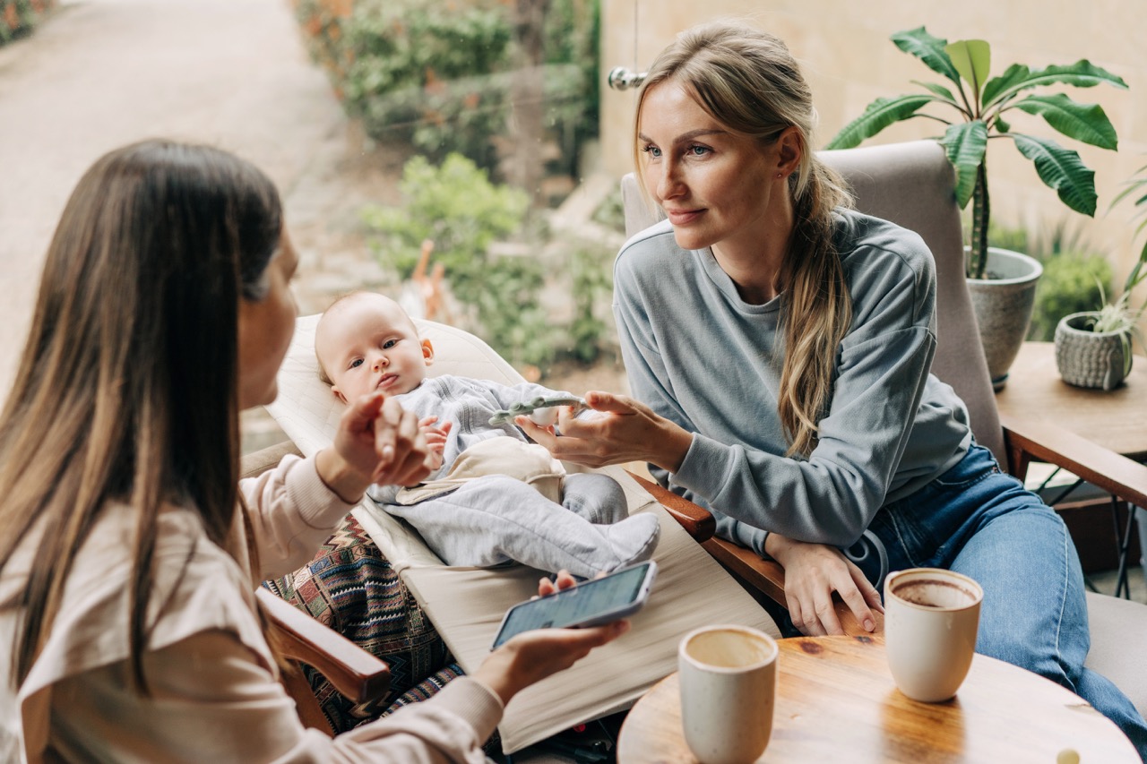 Zwei Mütter mit Baby beim Kaffee im Café